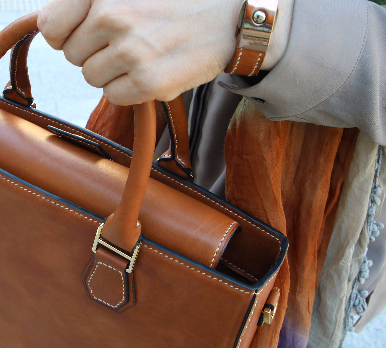 Italian artisan working on leather bag details in a traditional workshop.